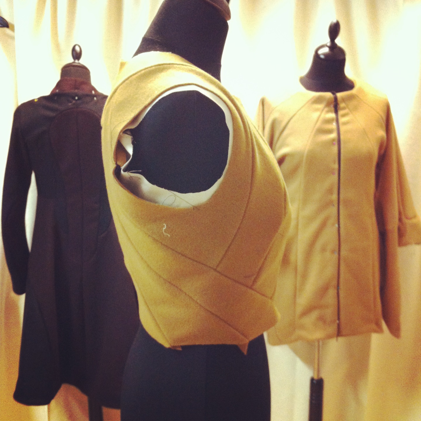 Side view of a gold-toned sleeveless garment on a dress form